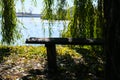 Forest park bench on the shore of a lake. Autumn weather mood Royalty Free Stock Photo