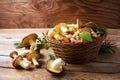 Forest picking edible mushrooms in wicker basket on wooden background