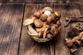 Forest picking mushrooms in wickered basket top view copy space. Fresh raw mushrooms and pumpki on the wooden table.Atumn