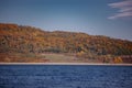 Forest reflected in the lake in autumn season. Beautiful landscape with colorful trees near the blue water Royalty Free Stock Photo