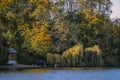 Forest reflected in the lake in autumn season. Beautiful landscape with colorful trees near the blue water Royalty Free Stock Photo