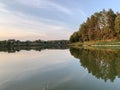 Forest reservoir in the middle of beautiful nature. Trees are reflected in the water of the lake. Evening landscape, a small pond Royalty Free Stock Photo
