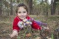 In the forest in the spring a little girl hugs the flowers to pa Royalty Free Stock Photo