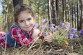 In the forest in the spring a little girl hugs the flowers to pa Royalty Free Stock Photo