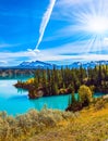 The forest surrounds the azure lake