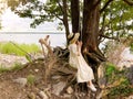 Forest trees on beach at sea and woman in white dress and straw hat  on a swing Royalty Free Stock Photo