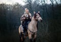 Forest Warrior: Blonde Viking Maiden on Horseback Conquering Medieval Wilderness with Her Fearless Spirit