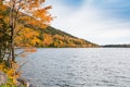Brilliant fall colors on a hillside curving along  the shore of a lake in Acadia National Park Royalty Free Stock Photo