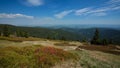 Forested hilly landscape with hazed valley in the background and clouds on a blue sky, Jeseniky mountains, Czech Republic