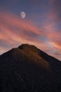 Forested mountain peak with moon at sunset Royalty Free Stock Photo