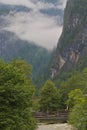 Forested mountain slopes and mountain ridges with silhouettes of evergreen coniferous trees shrouded in clouds and fog. Royalty Free Stock Photo