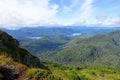 A forested valley with a beautiful blue lake in the middle, with the ocean in the background, on the west side of Graham island Royalty Free Stock Photo