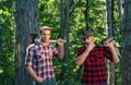 Foresters men. Man with serious face carries axe. Lumberjack brutal holds axe. Brutal lumberjack concept. Royalty Free Stock Photo