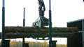 A forestry machine loads a log truck at the site landing. Forest machine down logs Royalty Free Stock Photo