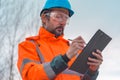 Forestry technician collecting data and writing at clipboard notepad