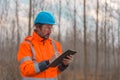 Forestry technician collecting data and writing at clipboard notepad