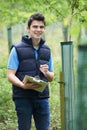 Forestry Worker With Clipboard Checking Young Trees