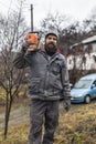 Forestry worker - lumberjack works with chainsaw. He cuts a big Royalty Free Stock Photo