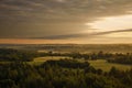 Forests and fields in the countryside and the sun shining through the clouds Royalty Free Stock Photo