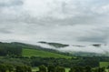 Foresty hills covered by this mist and rainy clouds.