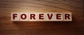 FOREVER word on wooden cubes on wooden Floor. Eternal love or trustworthy business longterm relationship concept