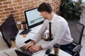 young businessman sitting near computers, smartphone Royalty Free Stock Photo