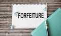 FORFEITURE - words on notepad on wooden background .Business concept