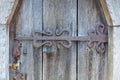 Forged antique hinge on a fragment of an old wooden door Royalty Free Stock Photo