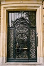 Forged door with glass inserts on the facade of a marble building Royalty Free Stock Photo