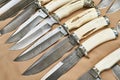 Forged hunting knives on beige Royalty Free Stock Photo