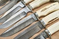 Forged hunting knives on beige Royalty Free Stock Photo