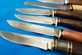 Forged hunting knives on blue Royalty Free Stock Photo