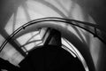 Forged iron twisted stairs with reflection on a red brick wall, handrails of the old vintage building, black and white