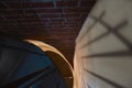 Forged iron twisted stairs with reflection on a red brick wall, handrails of the old vintage building, art