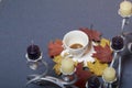 Forged metal candlestick with candles. A cup with unapproved coffee. Fallen autumn leaves of yellow and red are scattered on the s Royalty Free Stock Photo