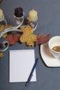 Forged metal candlestick with candles. A cup with unapproved coffee. There is an open notepad and a pen. Fallen autumn leaves of y Royalty Free Stock Photo