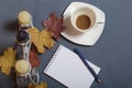 Forged metal candlestick with candles. A cup with unapproved coffee. There is an open notepad and a pen. Fallen autumn leaves of y Royalty Free Stock Photo