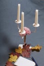 Forged metal candlestick with candles. There is an open notepad and a pen. Fallen autumn leaves of yellow and red are scattered on Royalty Free Stock Photo