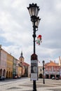 Forged metal lantern with theater poster and picture of little boy, gnome in red hat, town main Wallenstein square with colorful