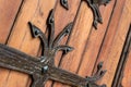 Forged pattern on door with decorative elements. Old vintage entrance, massive heavy wooden door of church or cathedral Royalty Free Stock Photo