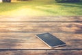 Forget and Lose Concept : Black smartphone place on wooden table at public park.