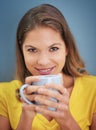 Forget love, fall in coffee. Portrait of a young woman drinking a cup of coffee against a grey background.