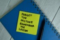 Forget The Mistake Remember The Lesson write on sticky notes isolated on office desk