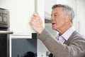 Forgetful Senior Man Looking In Cupboard Royalty Free Stock Photo