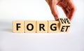 Forgive and forget symbol. Businessman turns a wooden cube and changes the word forgive to forget. Beautiful white background,