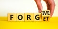 Forgive and forget symbol. Businessman turns a wooden cube and changes the word forgive to forget. Beautiful white background,