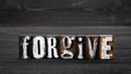 Forgive. Text from wooden blocks on a dark textured background Royalty Free Stock Photo