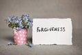 Forgiveness - text on white real paper with blue flowers