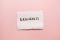 Forgiveness - text on white real paper with pink background