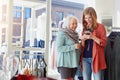 Forgot your bank card Who needs it anyway. a woman using her cellphone while out shopping with her mother.